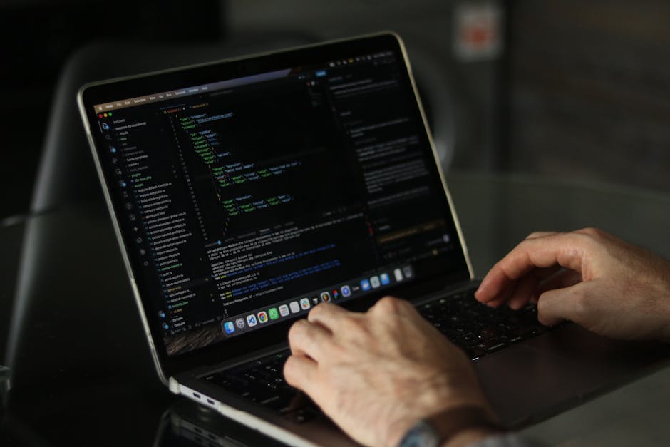 A close-up photograph of a computer screen displaying lines of HTML code in a text editor or development environment. The code includes tags and attributes with various colours such as blue, yellow, r